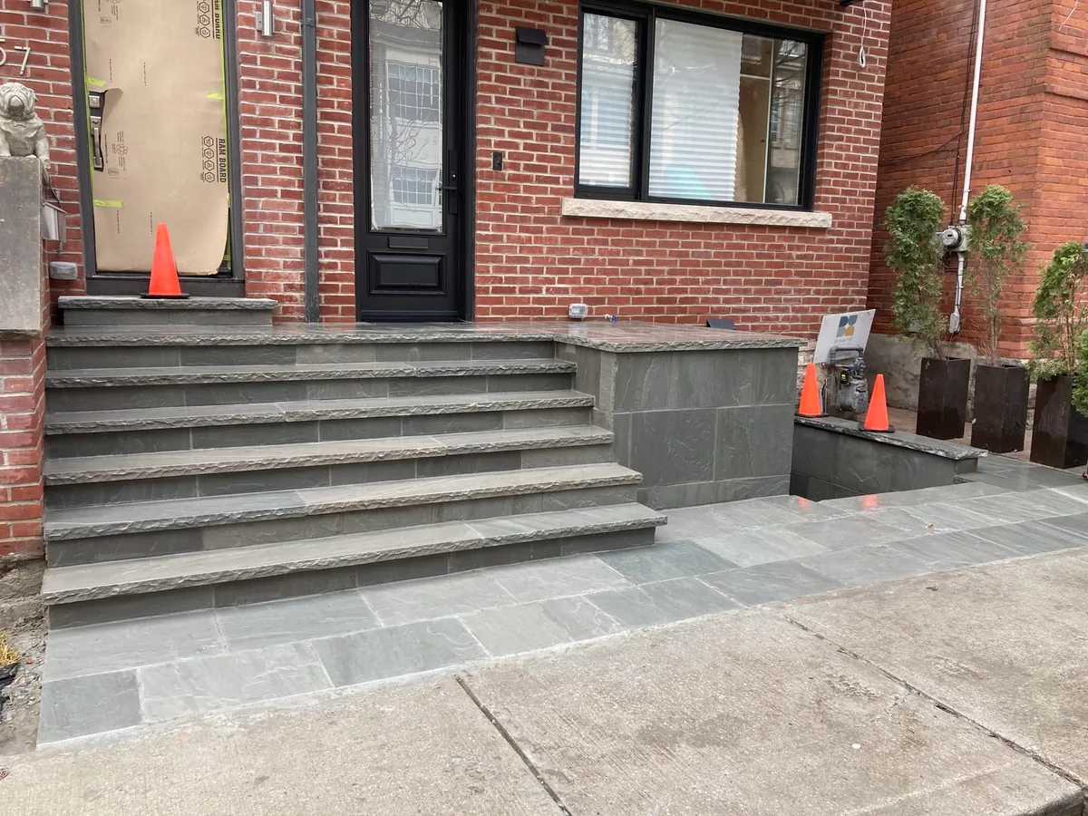 A closer view of the coping wall with a door and a gas meter visible.