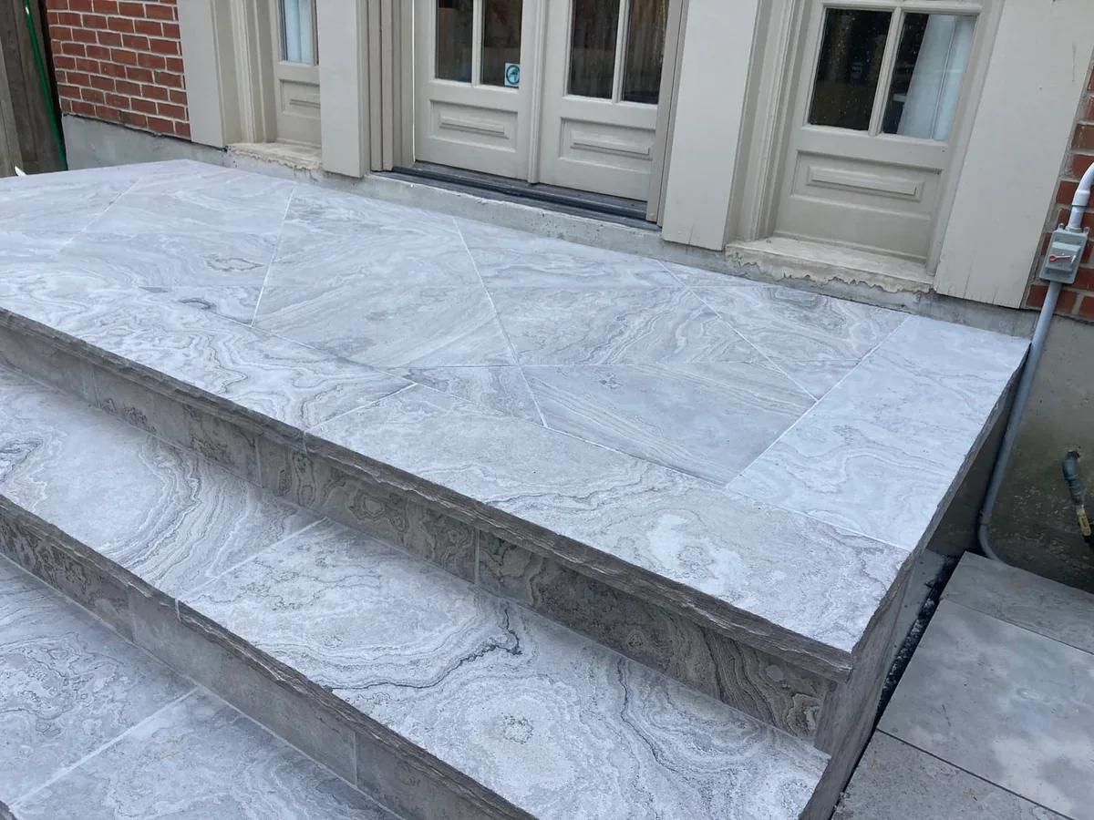 A marble diagonal-pattern patio near French doors and steps.