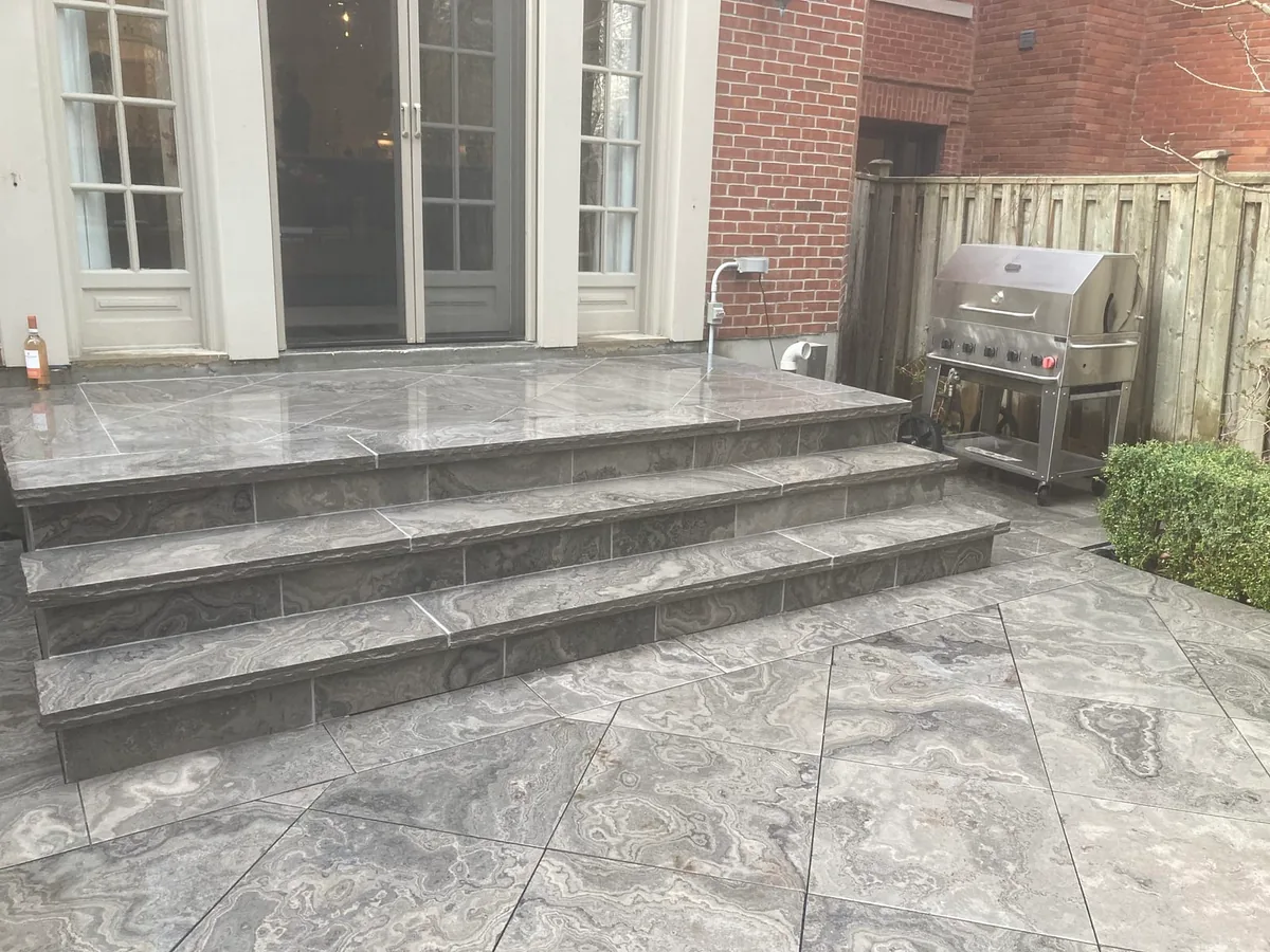 A similar view of the patio steps with the grill and French doors.