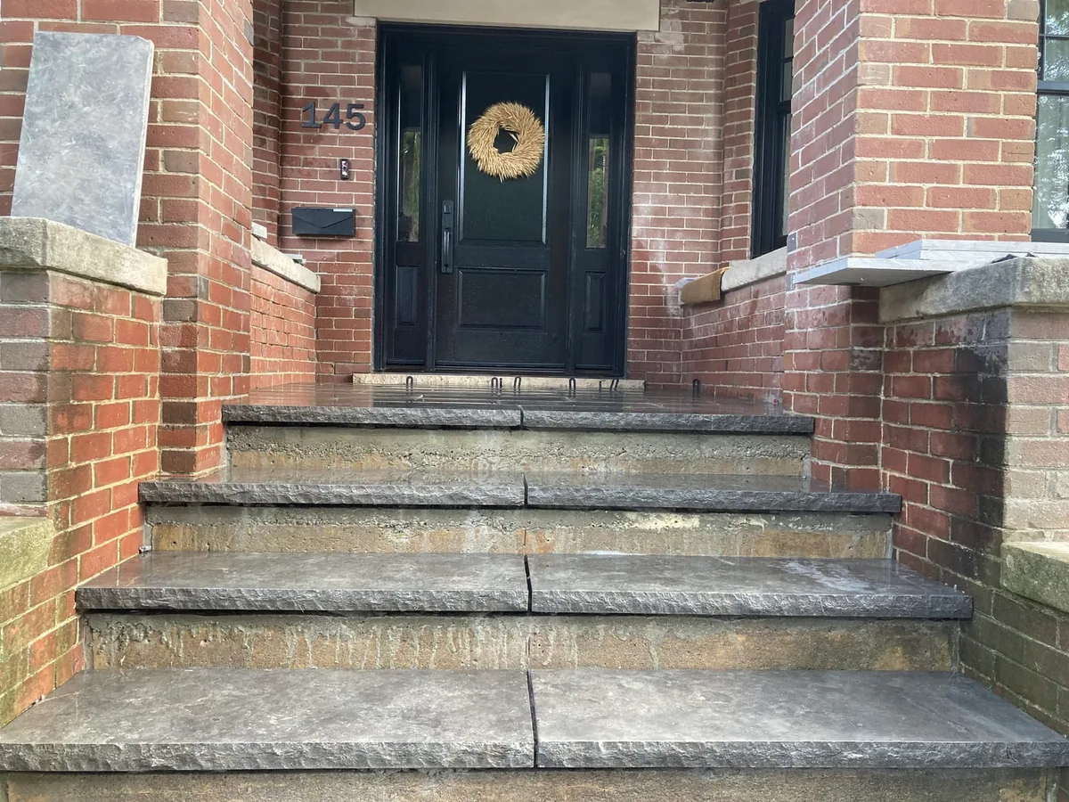 The finished stone steps with a wreath on the door, seen straight on.